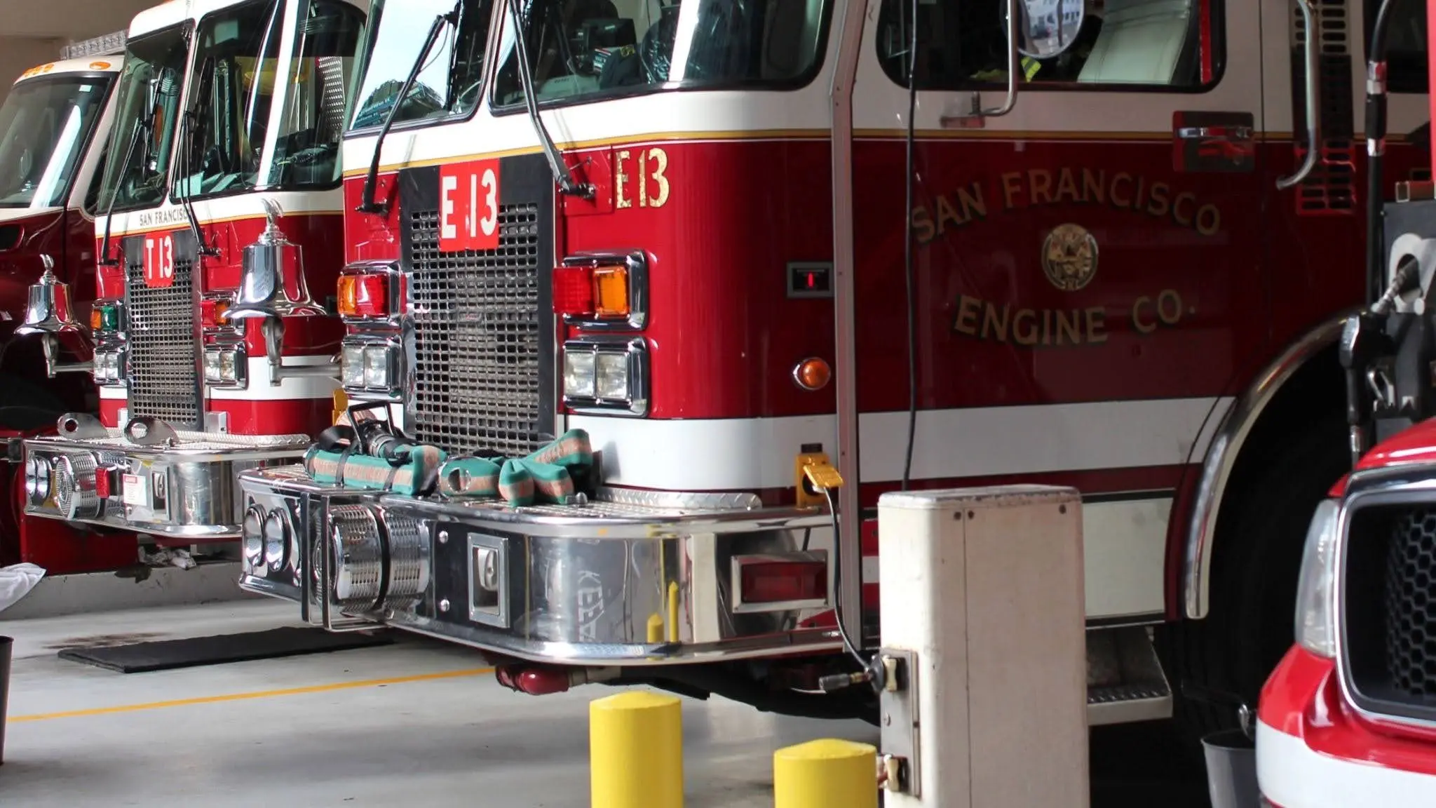 Fire trucks parked inside a fire station apparatus bay.
